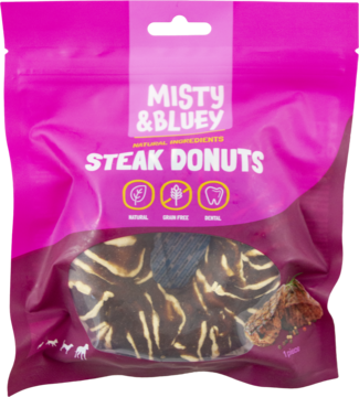 Frontalne ujęcie różowej torebki Misty & Bluey Steak Donuts, bezzbożowe, mięsne przysmaki dla psa w kształcie brązowych donutów.