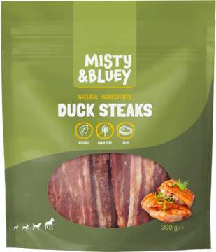 Zielone opakowanie przysmaków dla psa Misty & Bluey Duck Steaks. Widać paski mięsa z kaczki i gotowe steki.