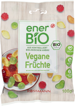 Przezroczysta torba enerBiO Vegane Früchte Rossmann. Zielona etykieta i rozsypane, kolorowe wegańskie żelki.
