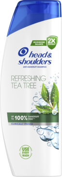 Biała butelka szamponu Head & Shoulders Refreshing Tea Tree, widok z przodu, z zielonymi liśćmi herbaty.