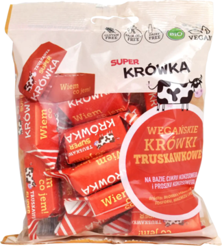 Ekologiczne wegańskie krówki truskawkowe Super Krówka w torebce z czerwonymi cukierkami, widok z przodu.