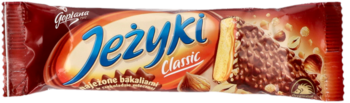 Jeżyki Classic, czekoladowy baton w czerwonym opakowaniu, z przodu widać herbatnik z polewą i orzechami.
