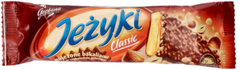 Jeżyki Classic, czekoladowy baton w czerwonym opakowaniu, z przodu widać herbatnik z polewą i orzechami.