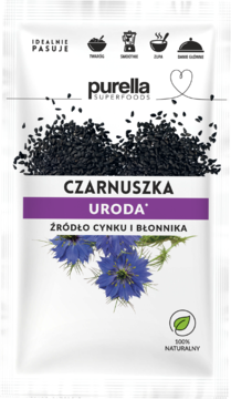 Purella SuperFoods Czarnuszka Uroda, biała torebka z nasionami i niebieskimi kwiatami, źródło cynku i błonnika.
