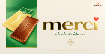 Kremowo-zielone opakowanie czekolady mlecznej Merci Hazelnut-Almond, złote logo, dwie czekoladki.
