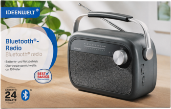 Radio IDEENWELT Bluetooth, ciemnoszare, z metalowym uchwytem, srebrnym pokrętłem i głośnikiem. Na stole, widok pod kątem.