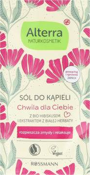 Alterra Sól do kąpieli z hibiskusem i białą herbatą, beżowa saszetka z różowymi kwiatami, widok z przodu.