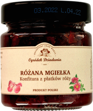 Szklany słoik konfitury "Różana Mgiełka" z płatków róży. Ciemnoczerwony dżem, widoczne płatki, beżowa etykieta, widok z przodu.