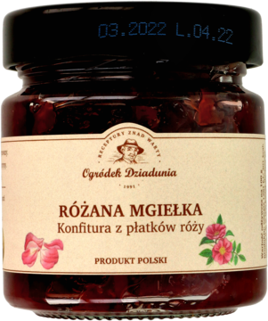 Szklany słoik konfitury "Różana Mgiełka" z płatków róży. Ciemnoczerwony dżem, widoczne płatki, beżowa etykieta, widok z przodu.