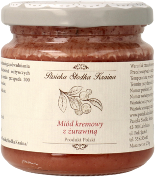Miód kremowy żurawinowy Pasieka Słodka Kraina w przezroczystym słoiku, etykieta z rysunkiem owoców, widok z przodu.