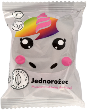 Opakowanie musującej tabletki do kąpieli Jednorożec, biała folia z wizerunkiem jednorożca i tęczową grzywą.