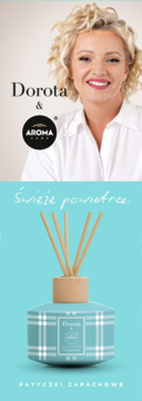 Odświeżacz Dorota & Aroma Home "Świeże powietrze": turkusowa butelka w kratę z patyczkami, pod portretem Doroty.