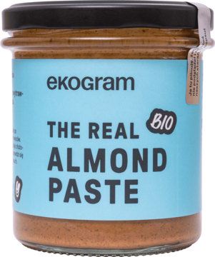 Ekogram THE REAL ALMOND PASTE BIO, prażona pasta migdałowa w szklanym słoiku z niebieską etykietą, widok z przodu.