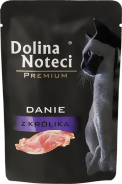 Czarna saszetka Dolina Noteci Premium, mokra karma dla kota, danie z królika, z białym kotem i grafiką mięsa.