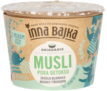 Inna Bajka Musli Pora Detoksu w brązowym kubku z zielonymi napisami, z migdałami i truskawkami, widok z przodu.