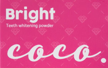 Jasnoróżowe opakowanie Coco Glam Bright Teeth whitening powder z białymi napisami: "Bright" oraz "coco.", widok z przodu.