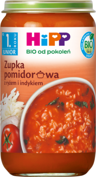 Pomarańczowy słoiczek Hipp BIO Zupka pomidorowa z ryżem i indykiem, z widoczną miseczką zupy i ryżem, widok z przodu.