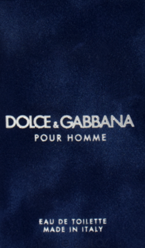 Dolce & Gabbana Pour Homme Eau de Toilette, srebrne logo na eleganckim, ciemnoniebieskim aksamitnym tle.