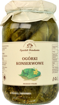 Słoik zielonych ogórków konserwowych „Ogródek Dziadunia” z widocznymi przyprawami na dole, widok z przodu.