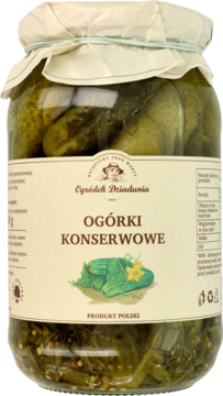 Słoik zielonych ogórków konserwowych „Ogródek Dziadunia” z widocznymi przyprawami na dole, widok z przodu.
