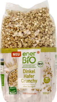 Przezroczysta torebka enerBio Dinkel Hafer Crunchy, widoczne chrupiące kawałki, logo Bioland i VEGAN.