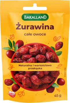 Żółta torebka Bakalland Żurawina, suszone całe owoce, z czerwoną miską żurawin i zielonymi liśćmi na przodzie.