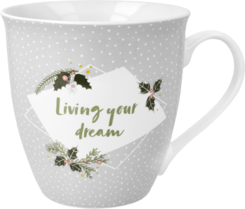 Szary ceramiczny kubek w białe kropki z świątecznym napisem "Living your dream" i motywem ostrokrzewu.
