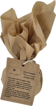 Kula do kąpieli z etykietą "Musująca, energia wody" zawinięta w brązowy papier kraft, widok z góry.