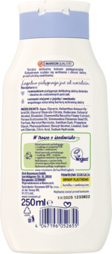Tył białej butelki Babydream balsam pielęgnacyjny z tekstem o rumianku, jojobie, awokado i symbolami recyklingu.