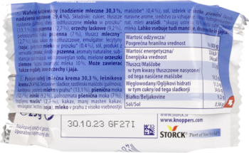 Zgniecione tylne opakowanie wafela Knoppers z polskimi napisami, datą ważności i tabelą wartości odżywczych.