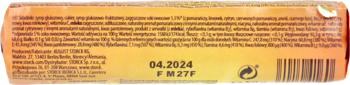 Tył pomarańczowego opakowania cukierków nimm 2 z datą ważności 04.2024, tekstem o witaminach i kodem kreskowym.