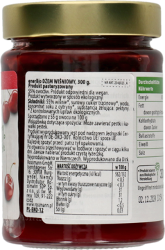 Tył szklanego słoika dżemu wiśniowego 300g ze złotą nakrętką. Widok z bliska na białą etykietę produktu pasteryzowanego.