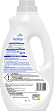 Tył białej butelki płynu do prania z uchwytem. Widoczne etykiety, instrukcje prania, kod kreskowy i symbol ostrzegawczy.