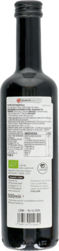 Ciemna butelka octu balsamicznego z Modeny, tył z białą etykietą, widoczne dane odżywcze, loga bio i wegan.
