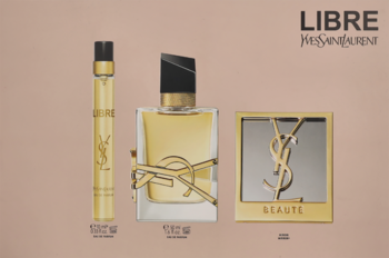 Zestaw YSL Libre: złota butelka perfum, flakonik podróżny, i kompakt YSL Beaute na beżowym tle.