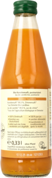 Tył butelki soku marchewkowego Alnatura Bio 0,33l. Pomarańczowy napój, zielona zakrętka, widoczna etykieta z datą.