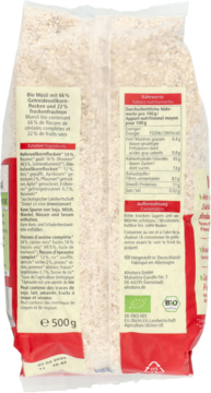 Tył przezroczystego opakowania Bio Müsli z pełnoziarnistymi płatkami i owocami, widoczne etykiety i certyfikaty.