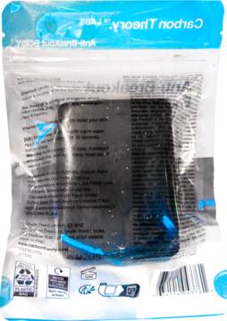 Tył przezroczystego opakowania złuszczającego mydła z węglem aktywnym. Widoczne czarne mydło i etykiety.