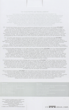 Tył białego opakowania lusterka Stylpro On Tour Petite Travel Mirror z wielojęzycznym opisem funkcji.