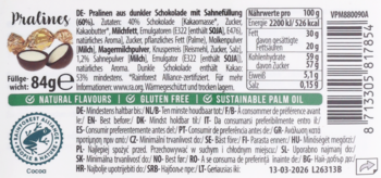Opakowanie 84g pralin z ciemnej czekolady i solonego karmelu. Widoczne dwa praliny: cały i przekrojony z jasnym nadzieniem.