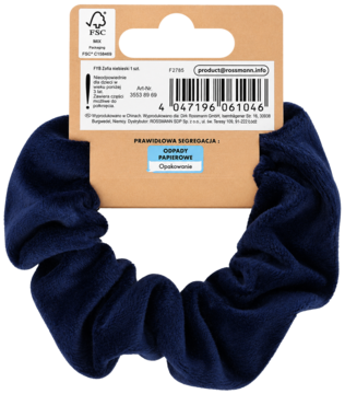Granatowa aksamitna gumka scrunchie z widoczną papierową metką produktu i kodem kreskowym na czarnym tle.