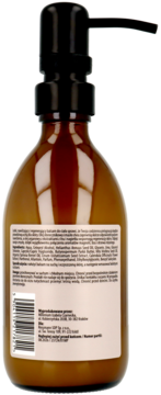 Tył brązowej butelki balsamu do ciała o zapachu magnolii, bzu i drzewa różanego, z czarną pompką i etykietą.