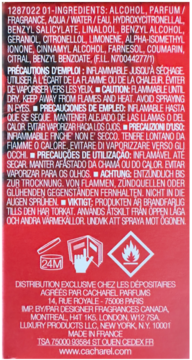Tył czerwonego opakowania perfum Cacharel z białym tekstem, listą składników i wielojęzycznymi ostrzeżeniami.