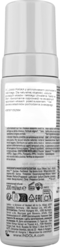 Tył białej butelki pianki do włosów Indola. Widoczne szczegóły etykiety z opisem produktu i składnikami.