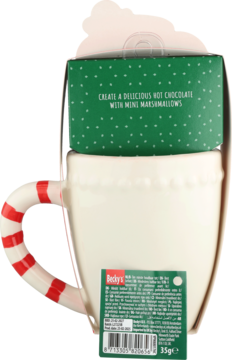 Tył białego kubka z uchwytem w czerwono-białe paski, nad nim zielone pudełko gorącej czekolady z piankami, widoczna etykieta.