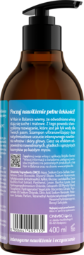 Tył brązowej butelki szamponu Hair In Balance Hydra z czarną pompką, niebiesko-fioletowa etykieta z tekstem o nawilżeniu.