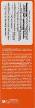 Tył pomarańczowego opakowania Pyunkang Yul Brightening Vita Toner z białymi etykietami, opisem i składem produktu.