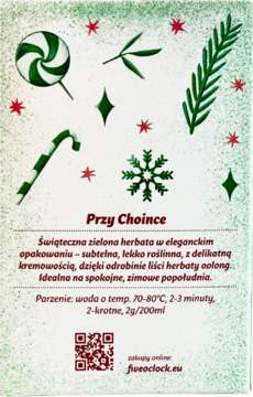 Opakowanie zielonej herbaty "Przy Choince" na białym tle z bożonarodzeniowymi motywami: lizak, cukierki, gwiazdki, choinka.
