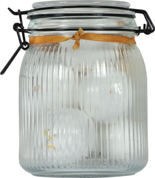 Szklany słoik z prążkowanego szkła z metalową klamrą, w środku białe kule do kąpieli, zdobiony pomarańczową wstążką.