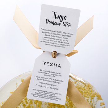 Yesha olejek do kąpieli jaśminowy: zbliżenie na dwie białe metki związane złotą wstążką.